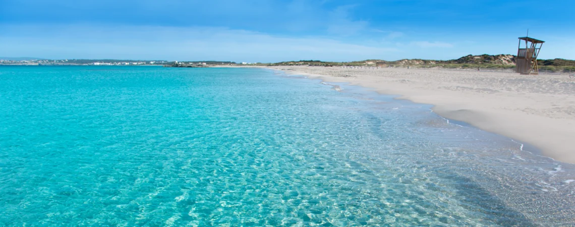 Playa de Llevant en Formentera, con agua turquesa cristalina y arena blanca bajo un cielo despejado