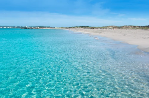 Playa de Llevant en Formentera, con agua turquesa cristalina y arena blanca bajo un cielo despejado